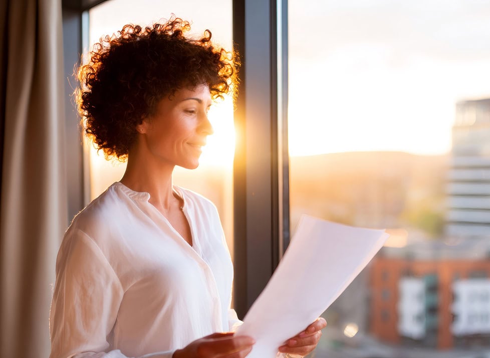 A Professional Woman Reading a Document on Paper